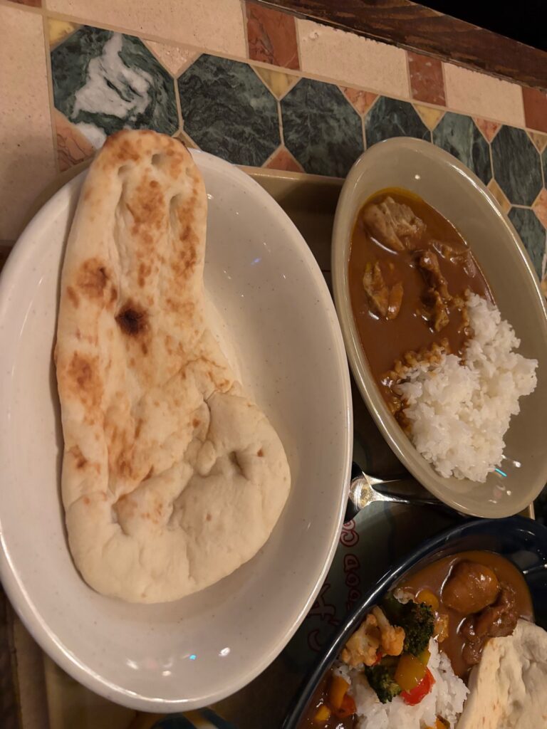 ライスと2種類のカレー、ナンが同じ皿に盛りつけられたカレー