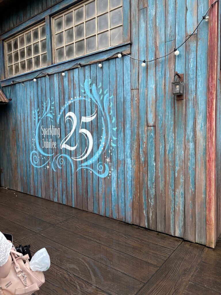 青い板壁に描かれた「Sparkling Jubilee 25」のロゴ